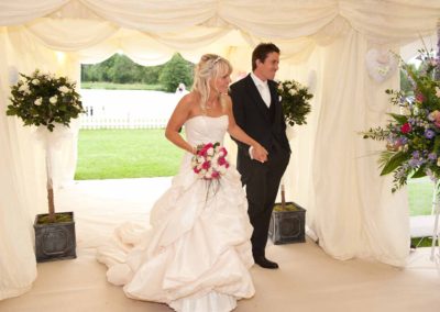 image of happy bride and groom entering marquee