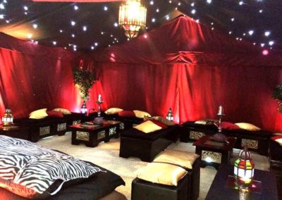 Image of Arabian Nights Themed marquee interior deep satin reds, gold cushions, exotic ceiling lightining