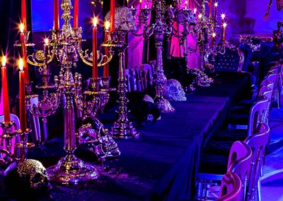 Image of Gothic wedding theme with dark purple accessories, long table, exotic black furnishings