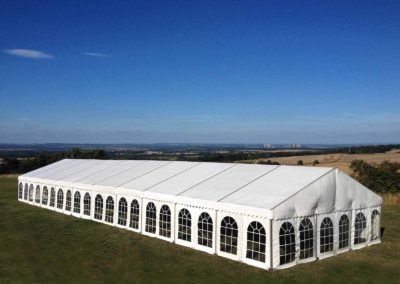 Image of large 12m corporate marquee viewed from the top of a hill on a beautiful summers day