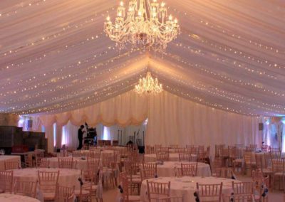 Image of Marquee with luxury chandeliers, and a half curtain (half-up) at rear of room
