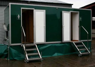 Image of raised portable toilets with steps leading to each stall