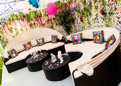 valentine party theme, floral background, beige/black sofas, floral hearts scattered across side tables. multi-colored cushions