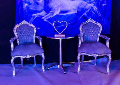 Image of silver velvet chairs under blue lighting